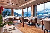 a restaurant with tables and chairs and mountains in the background at Hotel Bergkranz in Mieders