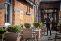um homem parado em frente a um prédio de tijolos em Clifden Station House Hotel em Clifden