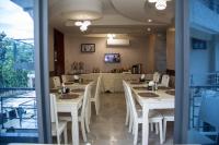 una sala da pranzo con tavoli bianchi e sedie bianche di Sunset Vista Hotel a Kigoma