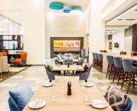 a dining room with tables and chairs and a fireplace at Holiday Inn Express Kolkata Airport by IHG in Kolkata