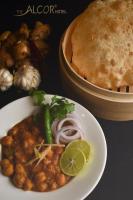 a plate of food with beans and a pie at The Alcor Hotel in Jamshedpur