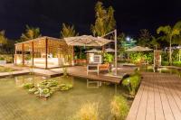 an outdoor patio with tables and umbrellas at night at Crowne Plaza Vientiane by IHG in Vientiane