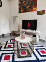 a living room with a table and a tv at STUDIO COSY LE Ti PARIS WIFI &amp; NETFLIX in Deuil-la-Barre