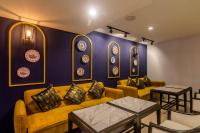 プーケットタウンにあるMontree Phuket Hotelの黄色いソファと壁に皿が掛けられたリビングルーム