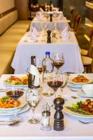 uma longa mesa com taças de vinho e pratos de comida em Hotel Prishtina em Pristina