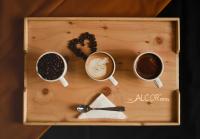 a wooden tray with three cups of coffee and beans at The Alcor Hotel in Jamshedpur