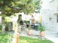 a garden with a stone oven in a yard at Gîtelabaronnaise avec piscine chauffée prés parc Asterix in Baron