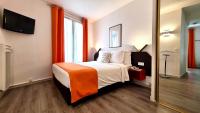a bedroom with a bed with an orange blanket at Boulogne Résidence Hotel in Boulogne-Billancourt