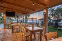 un patio con tavoli, sedie e vista sull'acqua di Porta del mar Beach Resort a Méson Yerakaríon