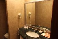 a bathroom with a sink and a mirror and a toilet at Wei-Yat Grand Hotel in Anping