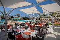 a restaurant with tables and chairs and a swimming pool at Faros Hotel Ayia Napa in Ayia Napa
