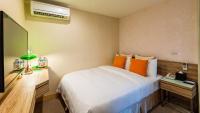 a bedroom with a bed with orange pillows at Hotel Color in Taipei