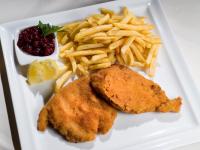 un plato de comida con pescado frito y patatas fritas en Tennenwirt Hotel, en Söll