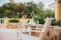 a table with wicker chairs and a vase of flowers at GRAND OTRADA Hotel Resort & SPA in Odesa