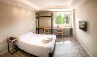 a bedroom with a bed and a desk and a window at Hotel Monaco in Ushuaia