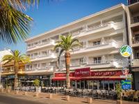 a large white building with palm trees in front of it at Les Palmiers in Fréjus