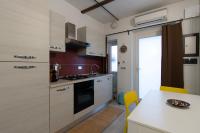 una cocina con armarios blancos y una mesa con sillas amarillas en Santa Chiara, en Turín