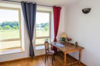 a dining room with a table and two windows at Domaine de kerbillec in Theix