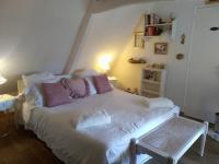 1 dormitorio con cama blanca y almohadas rosas en la maison du phare DE HONFLEUR chambre d hôtes B&amp;B -jacuzzi privé- shabby chic, en Honfleur