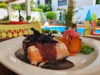 ein Teller mit Fleisch und Gemüse auf einem Tisch in der Unterkunft Jardín Mérida in Mérida