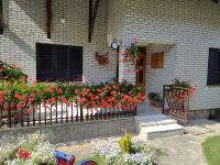 a fence with flowers in front of a house at Apartmani Mali Raj Rudnik in Rudnik