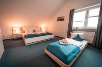 a bedroom with two beds and a window at Airport Lounge Hotel Düsseldorf in Düsseldorf