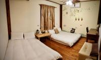 a room with two beds and a table and a couch at Share B&amp;B in Puli