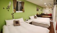 two beds in a room with green walls at Share B&amp;B in Puli