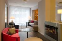 a living room with red chairs and a fireplace at Holiday Inn Vienna City by IHG in Vienna