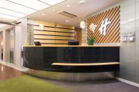 an office lobby with a black counter and a bench at Holiday Inn Vienna City by IHG in Vienna