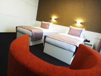 a room with two beds and a red couch at Hotel Vitality in Vendryně