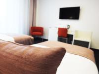 a hotel room with two beds and a flat screen tv at Hotel Vitality in Vendryně