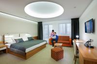 a hotel room with a bed and a woman at Hotel Vitality in Vendryně