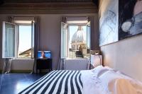 a bedroom with a bed and a view of a building at Palazzetto Rosso - Art Hotel in Siena