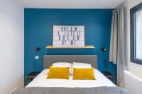 a blue bedroom with a bed with yellow pillows at NOCNOC - Le Michelangelo in Lyon