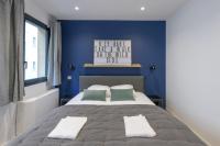 a bedroom with a large bed with blue walls at NOCNOC - Le Michelangelo in Lyon