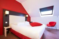 a hotel room with a bed and a red wall at KYRIAD ROUEN NORD - Mont Saint Aignan in Mont-Saint-Aignan