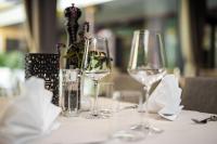 a table with wine glasses and a vase with flowers at Hotel Andreas Hofer in Kufstein