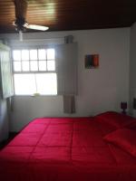a bedroom with a large red bed with a window at Casa com Piscina Paraty in Paraty