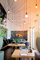 Un restaurante con mesas, sillas y luces. en Hotel Restaurant Fronmühle 3 Sterne Superior, en Bad Dürkheim