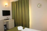 a hotel room with a green shower curtain and a clock at Stop Hotel in Braşov