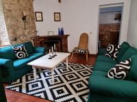 a living room with green couches and a coffee table at Complejo Rural Huerta Grande in Algeciras