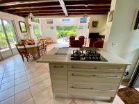 a kitchen and dining room with a stove top oven at Cottage with a big idyllic garden at the lake in Lacanau