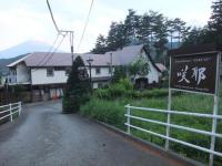a sign in front of a house with a fence at Guesthouse Sakuya in Fujikawaguchiko
