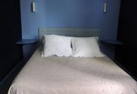 a bed with two blue walls and two pillows at Chambres d&#39;hôtes d&#39;Accolay in Accolay