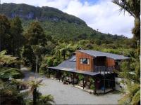 una casa en medio de una montaña en Te Nikau Retreat, en Punakaiki