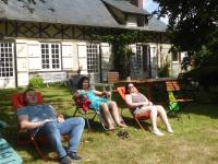 a group of people sitting in chairs in the yard at Orfea s home - maison de charme, Lyons-la-Forêt, accès direct forêt in Le Tronquay