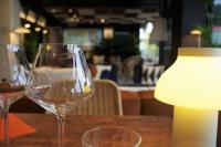 リュネルにあるIbis Lunel Petite Camargueのランプの付いたテーブルの上にワイングラスが2つ