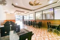 a restaurant with tables and chairs and a ceiling fan at Golden Park Inn in Jarmundi