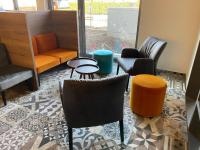 Habitación con sillas, mesas y sofá en Emils Hotel, en Pirmasens